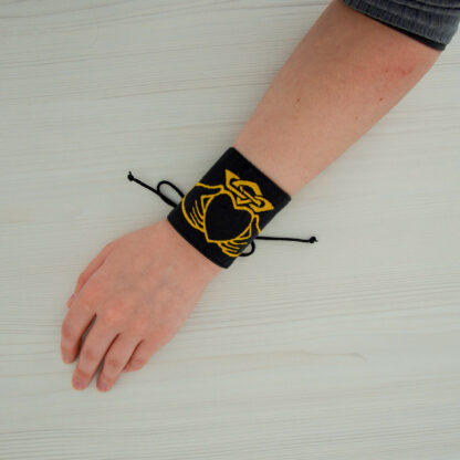 Bracelet en tissu noir brodé en doré d'un Claddagh, photo porté