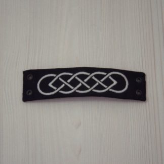 Bracelet noir brodé en blanc d'un motif de nœud celtique